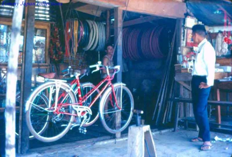 a man standing next to a red bike