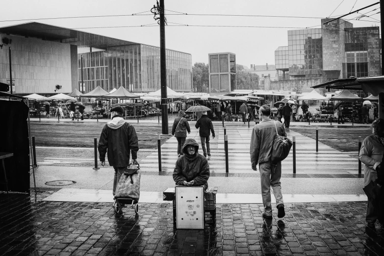 people with umbrellas are walking along the sidewalk