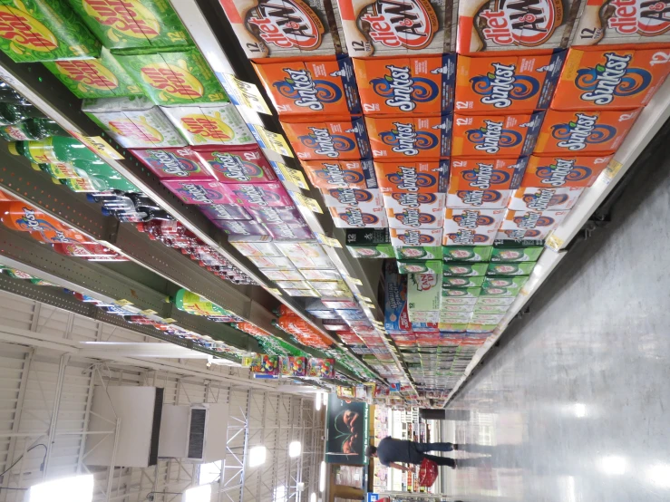 rows of orange and white sodas on the shelf at a grocery store