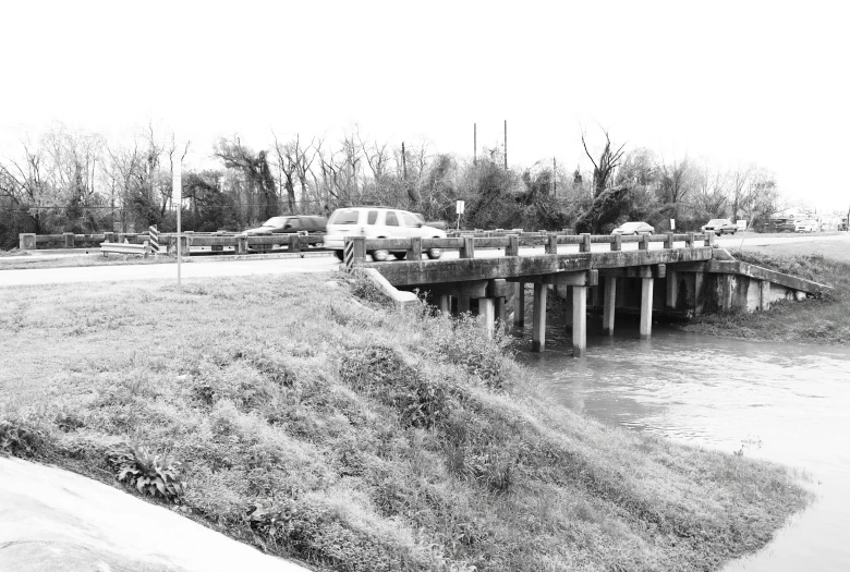 the cars are passing over a long wooden bridge