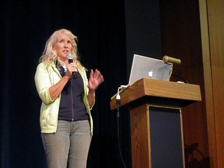 a person stands on stage with a microphone