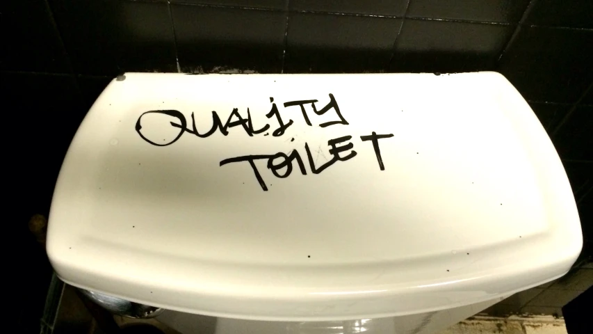 a white toilet seat with a writing written on it