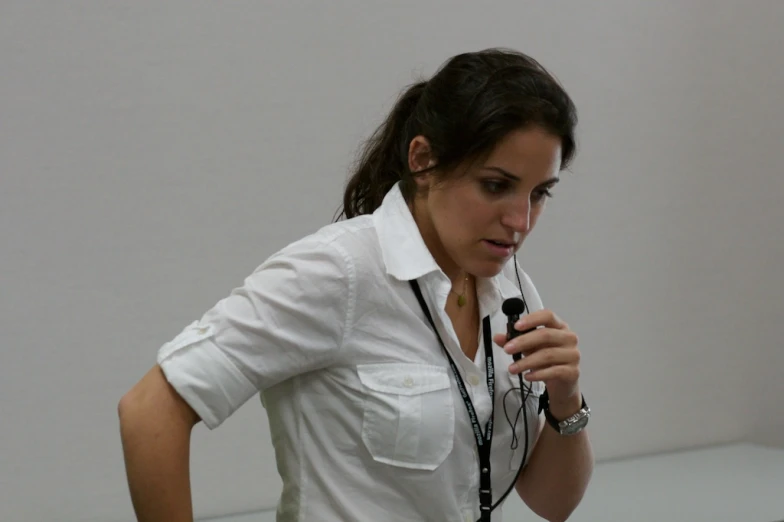 a woman in a white blouse is holding a black microphone