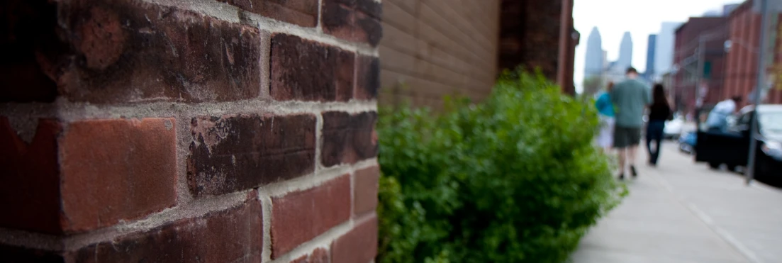 a person standing by a brick wall