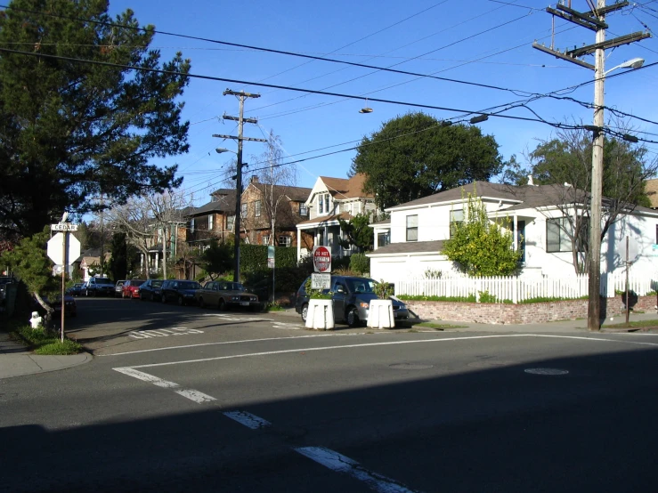 a street corner with some houses and a few cars