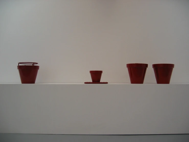 three vases are lined up on the shelf