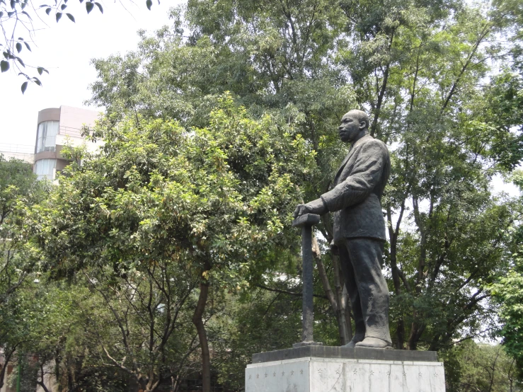 a statue is in front of a group of trees