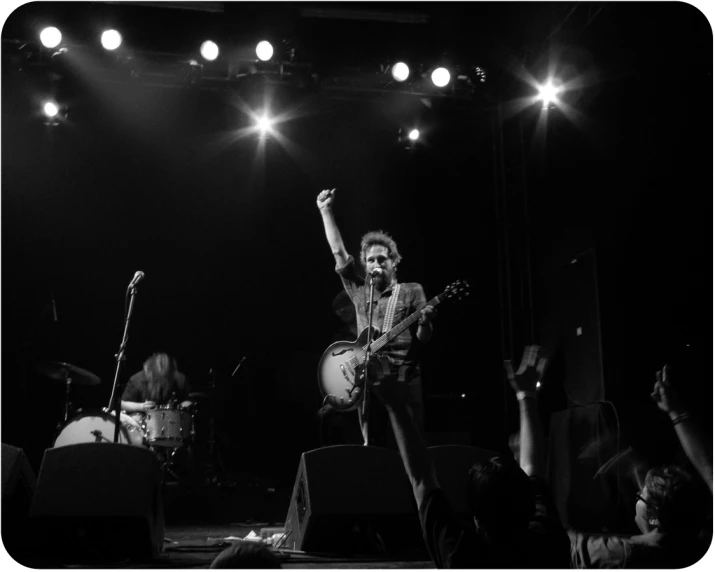 a person playing guitar and singing on stage