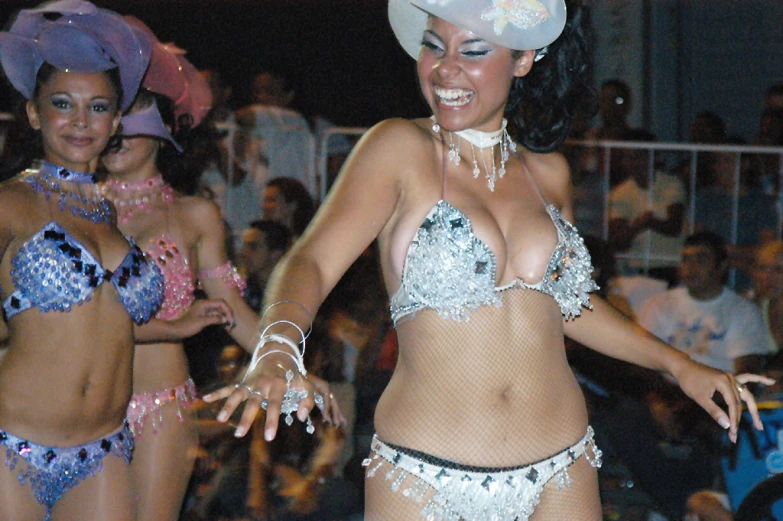 two woman in matching swim suits standing in front of a crowd