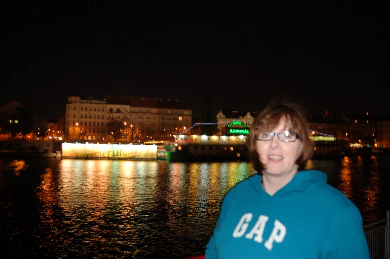 a woman standing next to water at night