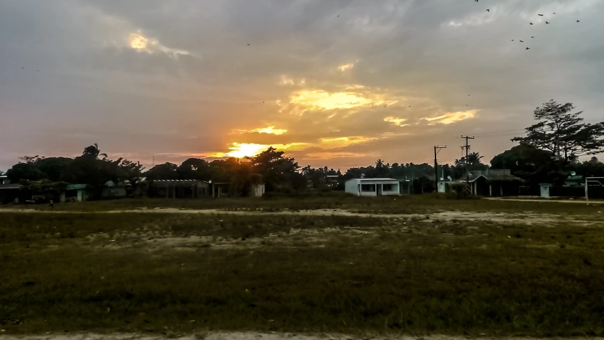 the sun is setting over a neighborhood on the other side