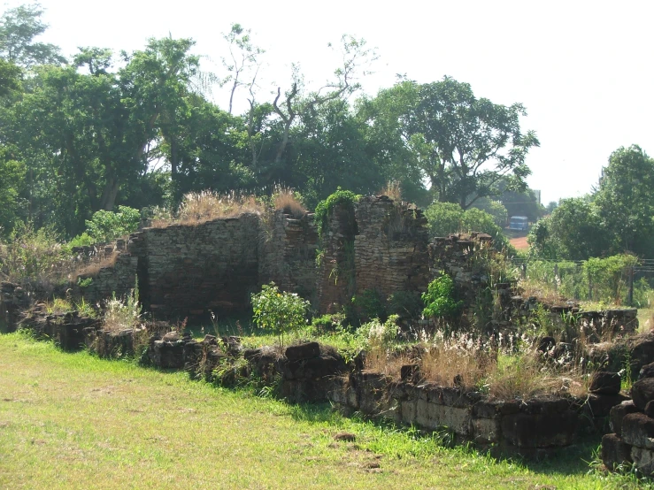 a row of old brick buildings standing in the grass