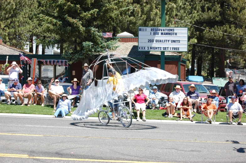 a woman riding a bike past a crowd