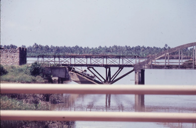 a bridge spans over the river in front of an industrial park