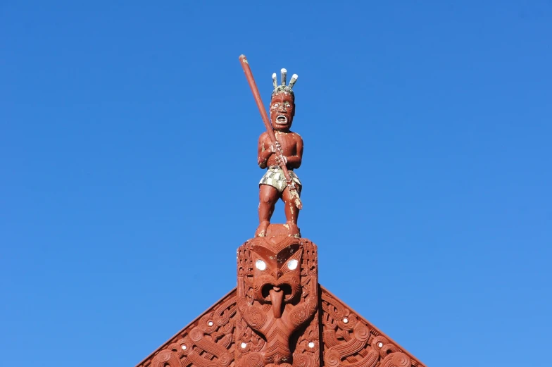 a large statue atop a building under a blue sky