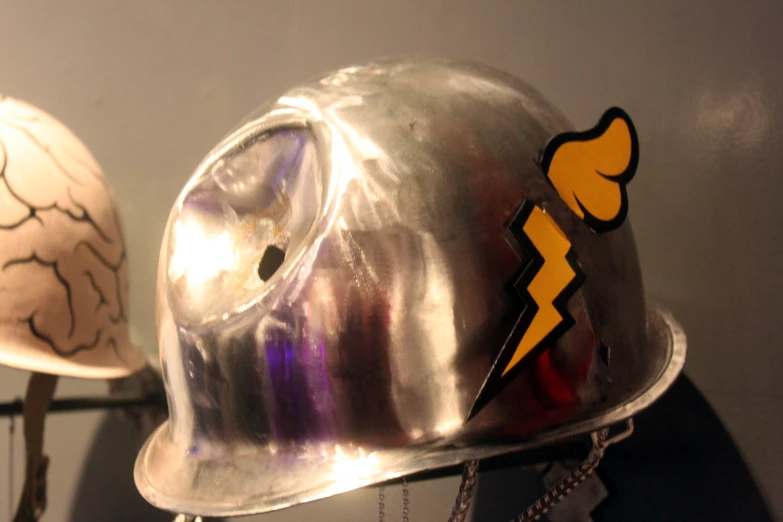 a silver helmet is decorated with a lightning symbol