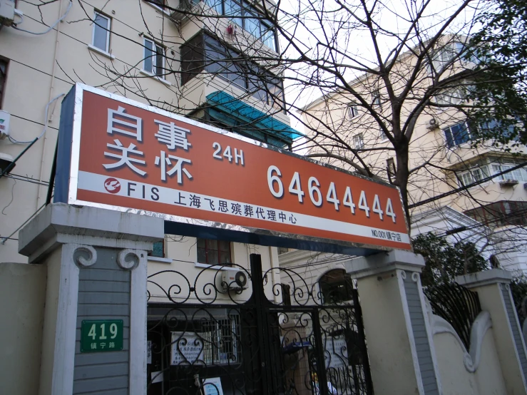 a tall orange sign with japanese writing on it