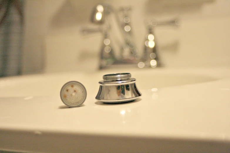 there is a chrome bathroom sink with a stopper next to it