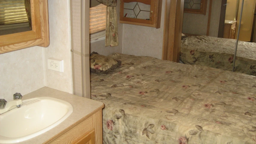a bed and mirror inside of a small camper