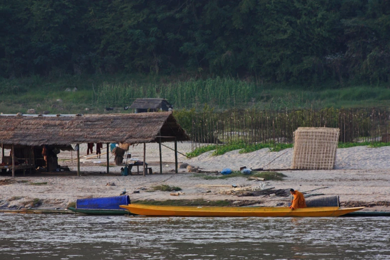 people on a beach near houses by water