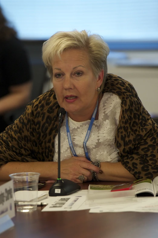 a woman is seated at a table with several papers