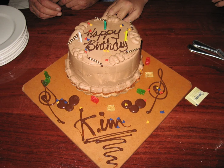 two people celeting a cake with a name