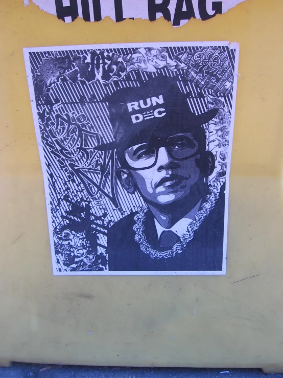 a poster on a yellow wall that has a picture of a man in a hat and glasses