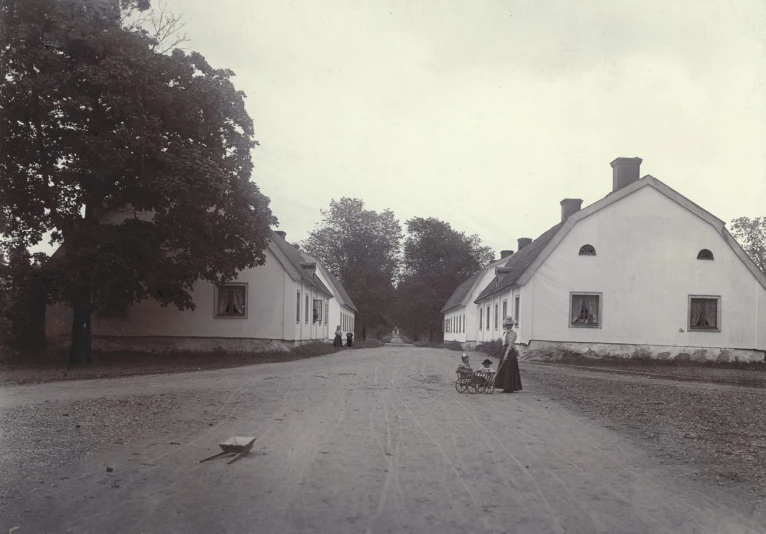 two white houses on either side of a dirt road