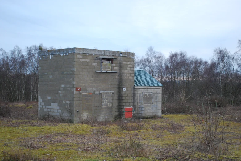 an old outhouse in a field with no grass