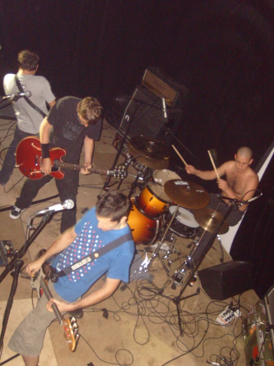 several young men playing drums together with instruments