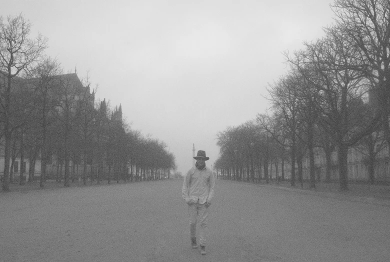 a black and white po shows a person in white walking down a pathway