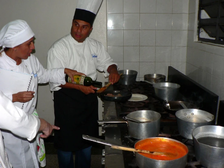 there are two chefs cooking food in a kitchen