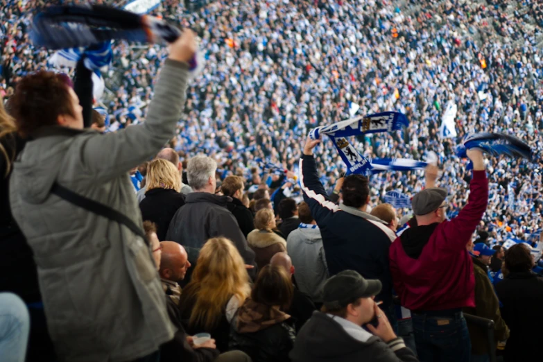 a woman holding up some blue things and other people