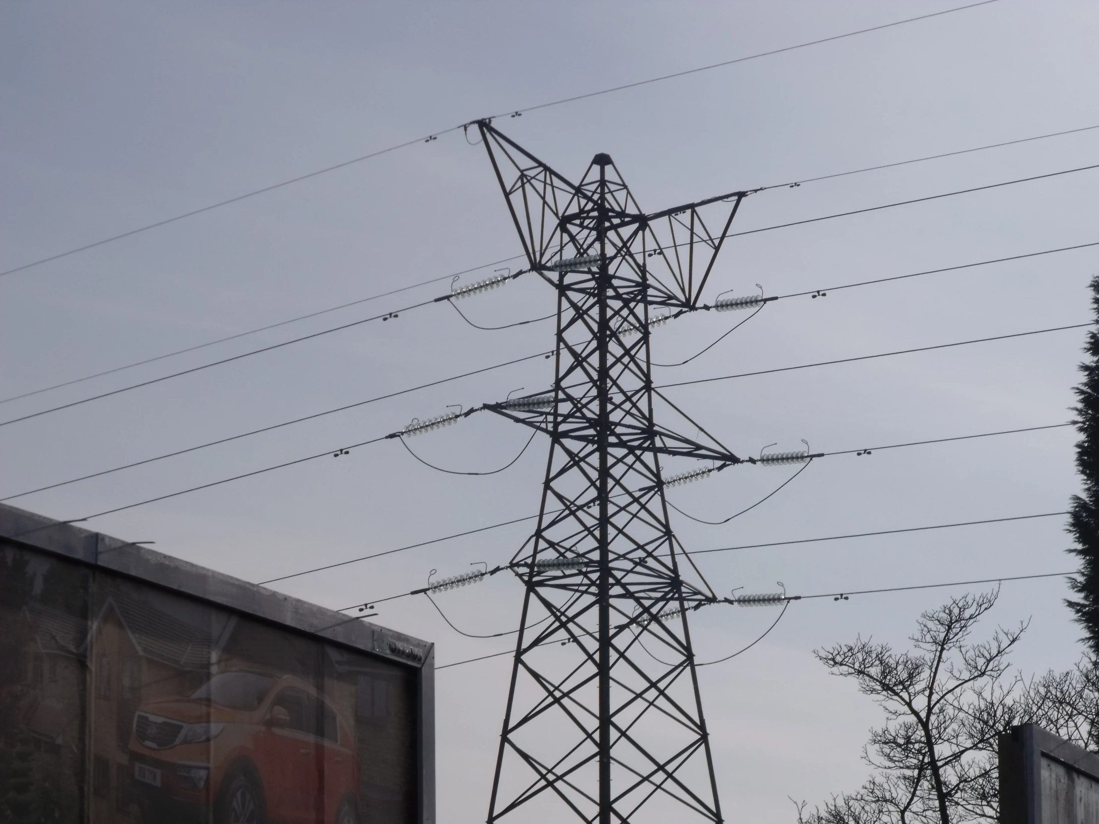 electrical towers are in the foreground, one standing upright