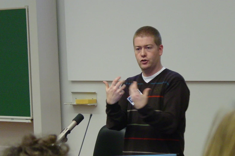 a man standing in front of a whiteboard with microphone