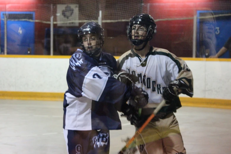 two boys playing ice hockey in their uniforms