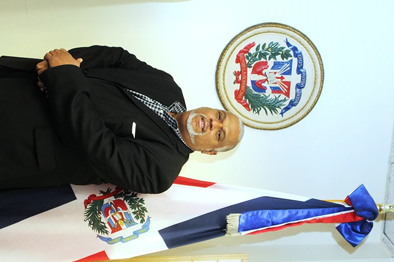 a man in a black suit standing next to flags
