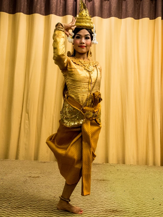 a woman in costume with an umbrella stands on her head