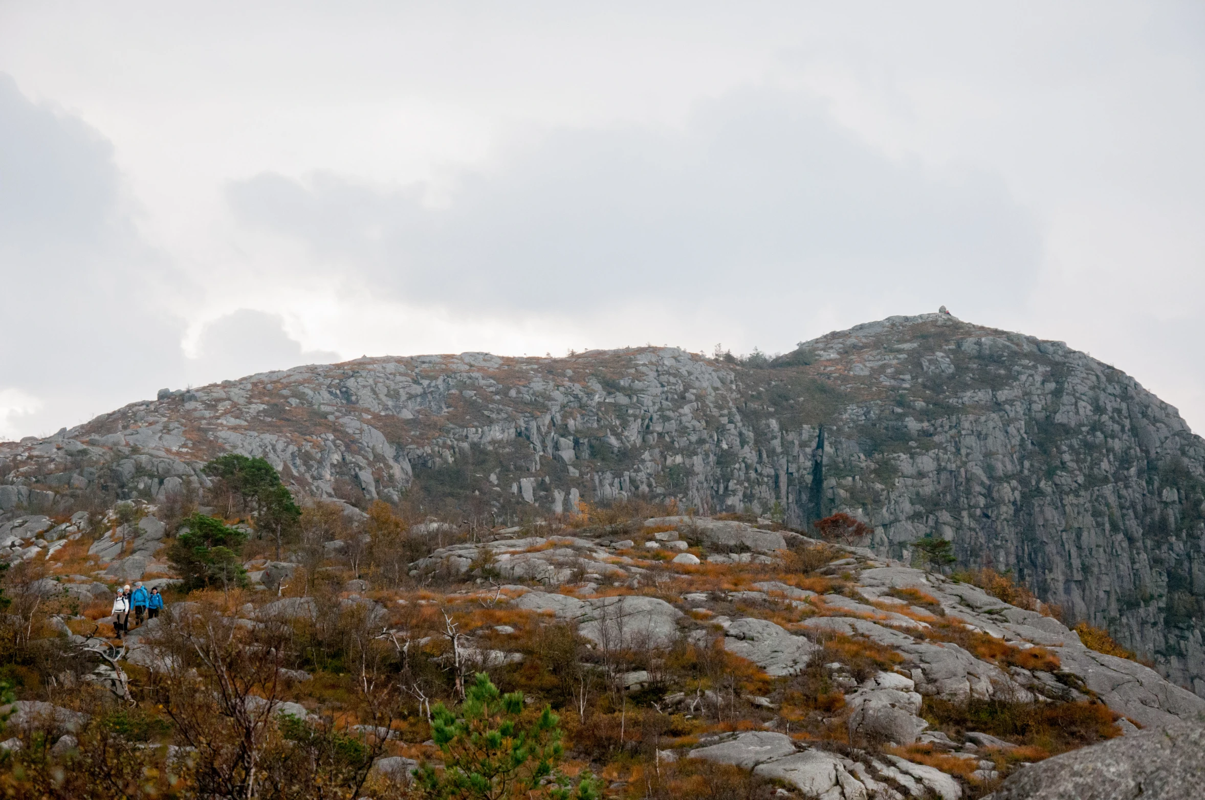 some people stand on some rocks near a rock