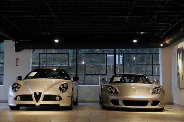 two fancy cars are parked inside a showroom
