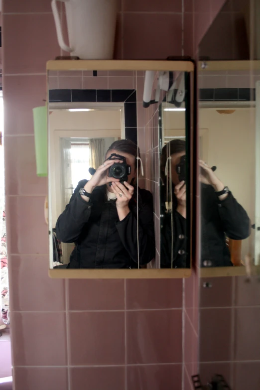 a person taking a picture in the mirror with his camera