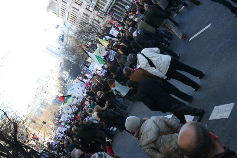 several people in white jackets standing in a long line on the side of the road