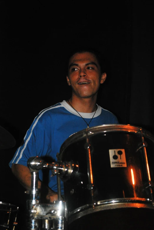 a man is playing drums while sitting on the ground