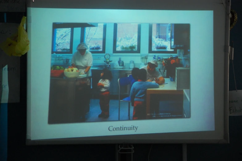 people and children are gathered in the kitchen