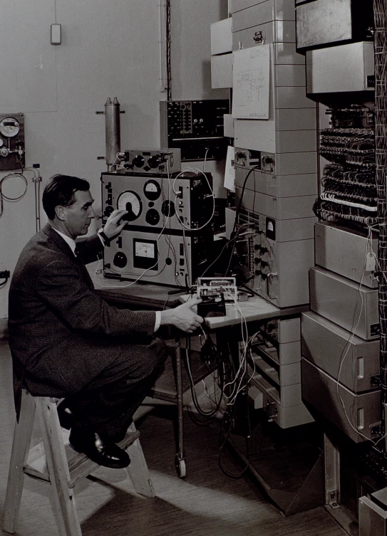 man in suit sitting at work site looking at electronics