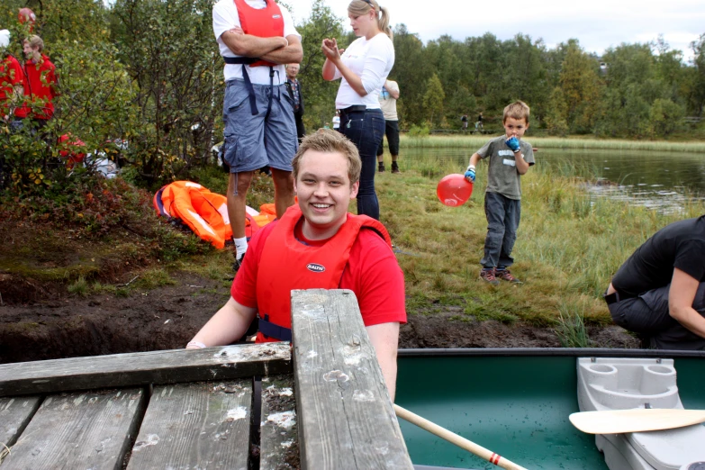 a woman with orange life jackets on stands in a boat