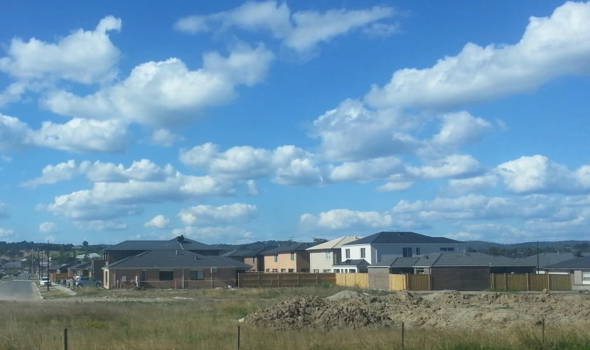 some white and gray houses buildings a dirt road and grass