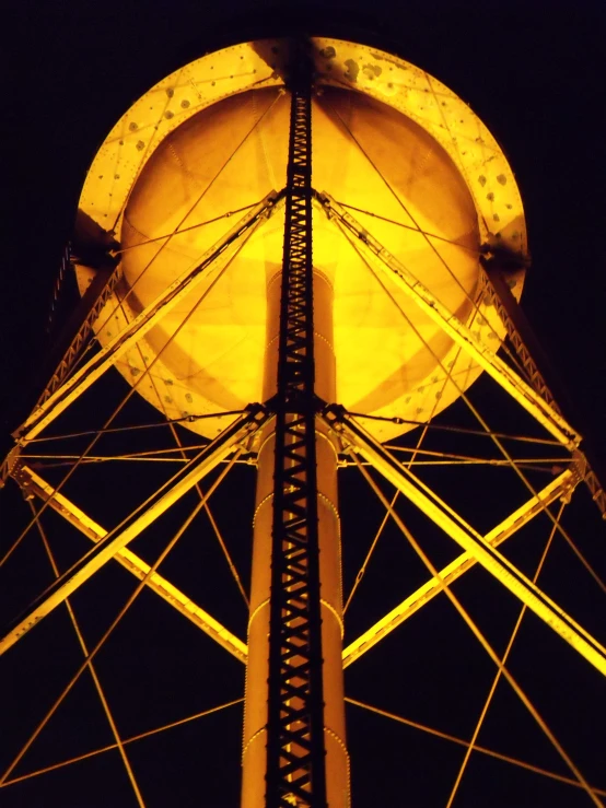 the top of a water tower lit up at night