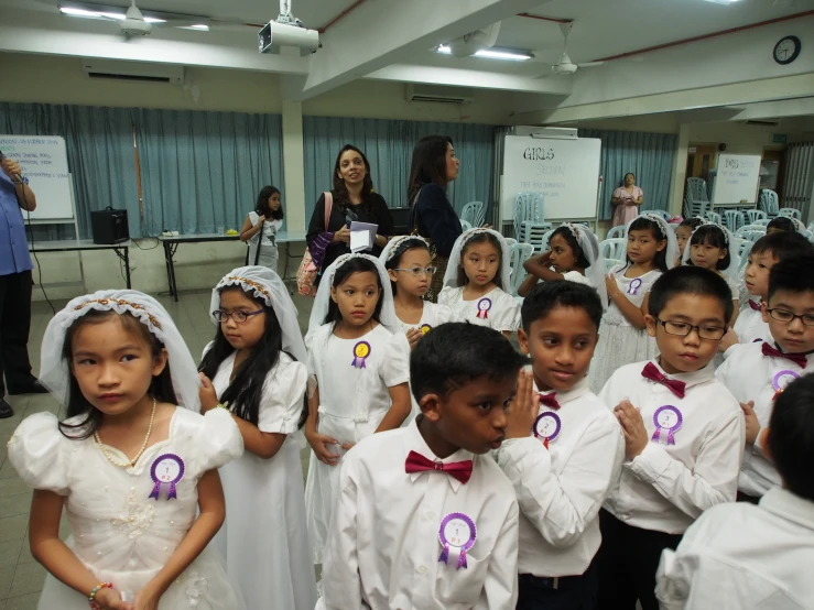 young children in white dresses are smiling for the camera