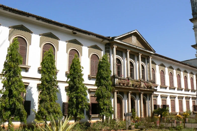 white building with trees lining the sides and a clock tower